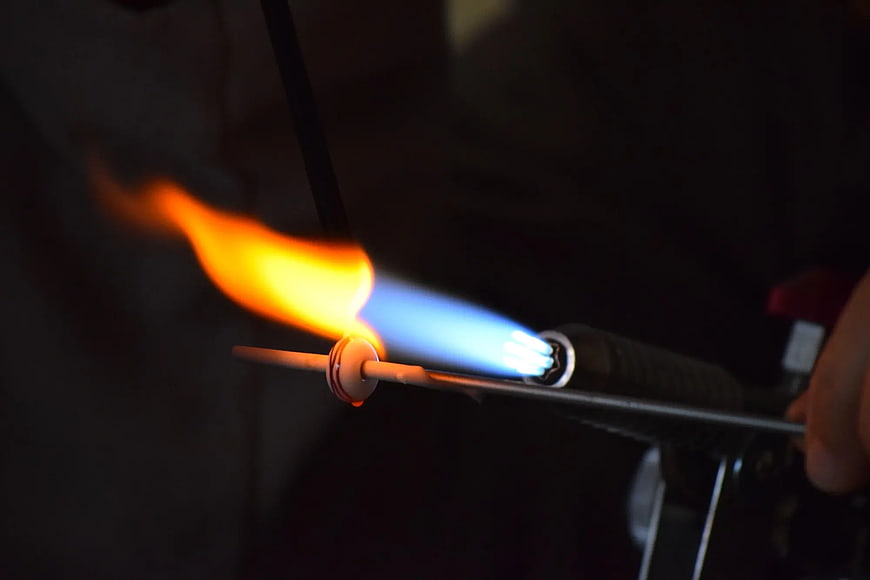 Close-up of blowtorch flame melting metal rod