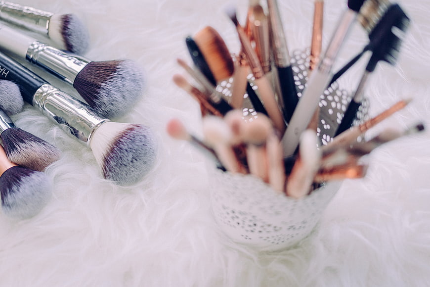 Makeup Brushes on White Fur Background