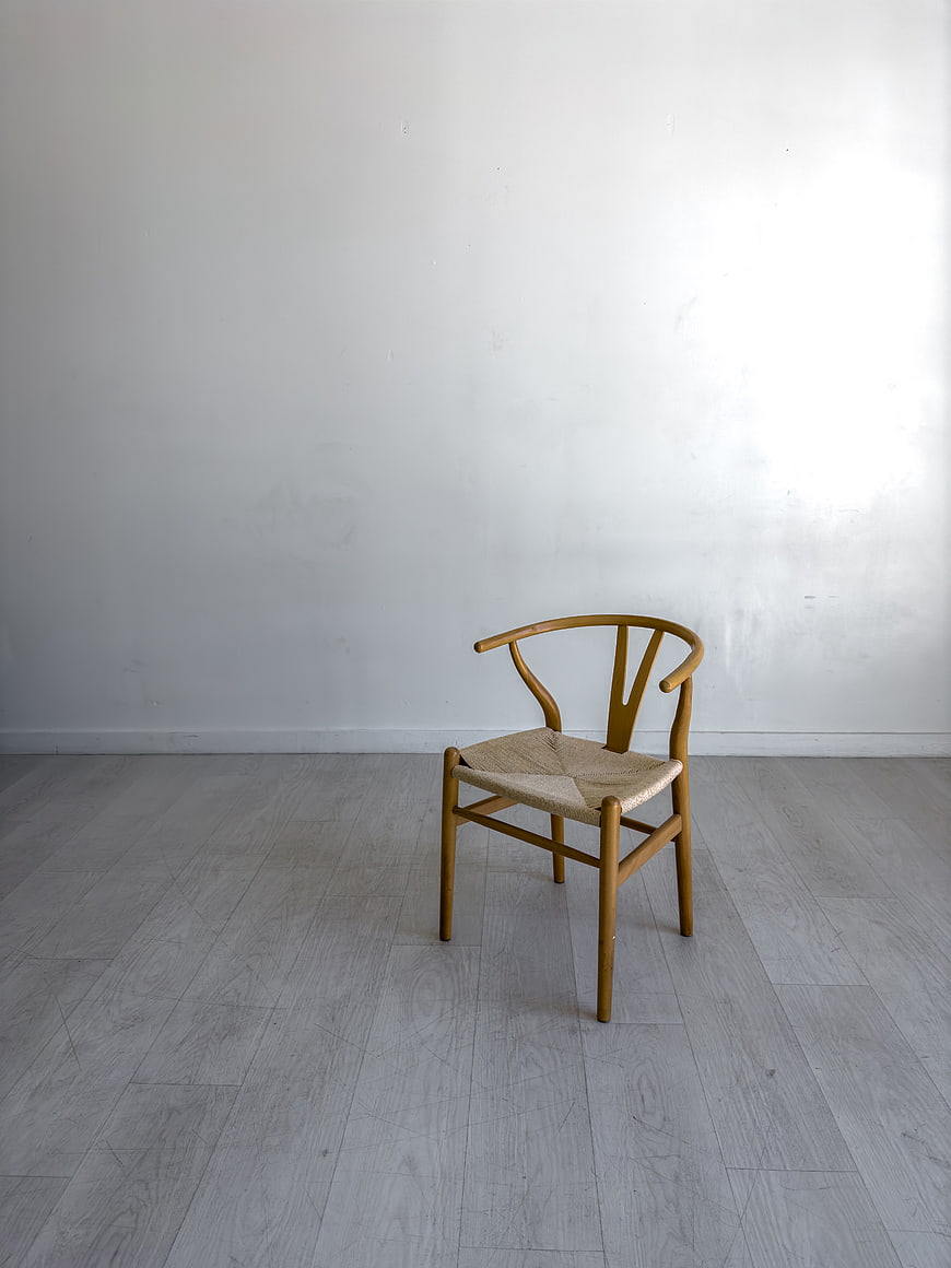 Minimalist wooden chair in empty white room interior
