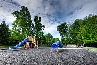 Empty playground with blue slide and tunnel in park