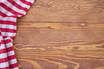 Red and white checkered cloth on rustic wooden table background