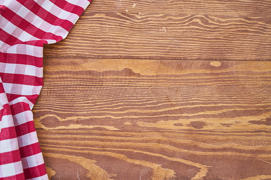 Red and white checkered cloth on rustic wooden table background