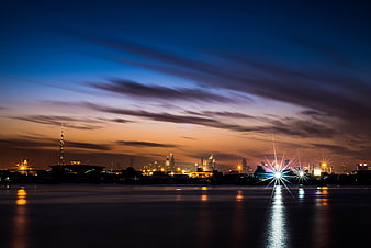 Dramatic city skyline at dusk with water reflections