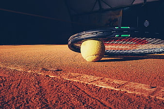 Tennis Racket and Ball on Clay Court Surface