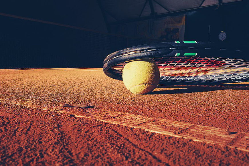 Tennis Racket and Ball on Clay Court Surface