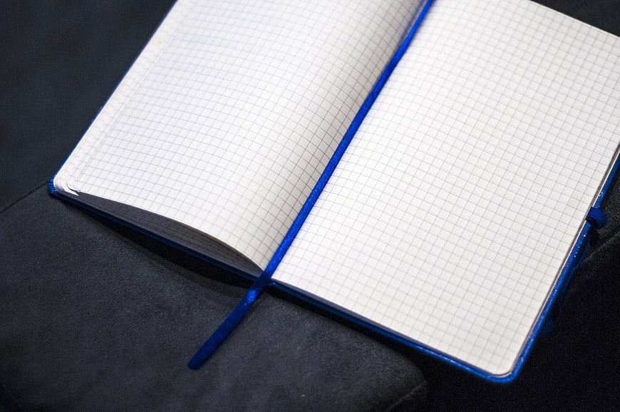 Open Blue Grid Notebook on Dark Surface