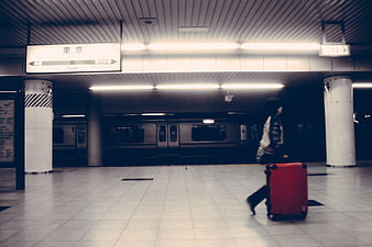 Traveler with red suitcase walking in Tokyo subway station