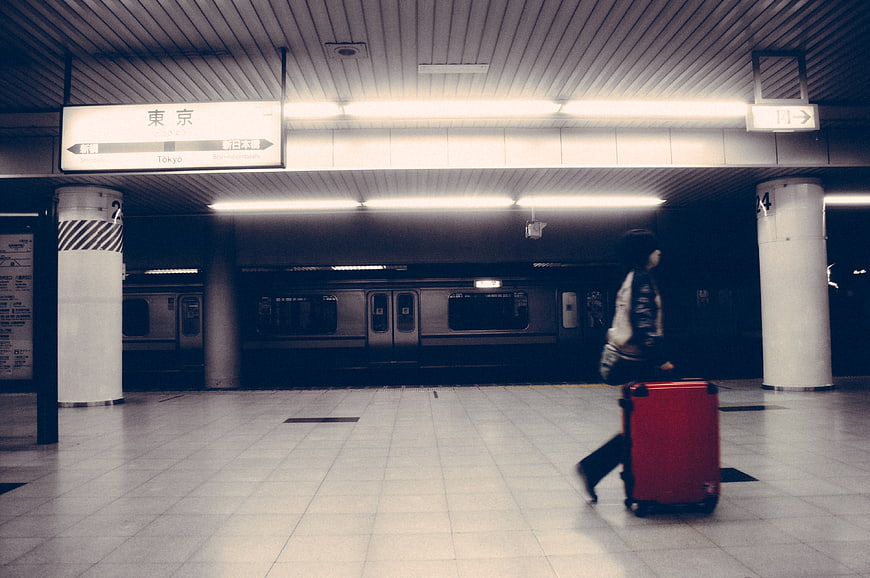 Traveler with red suitcase walking in Tokyo subway station