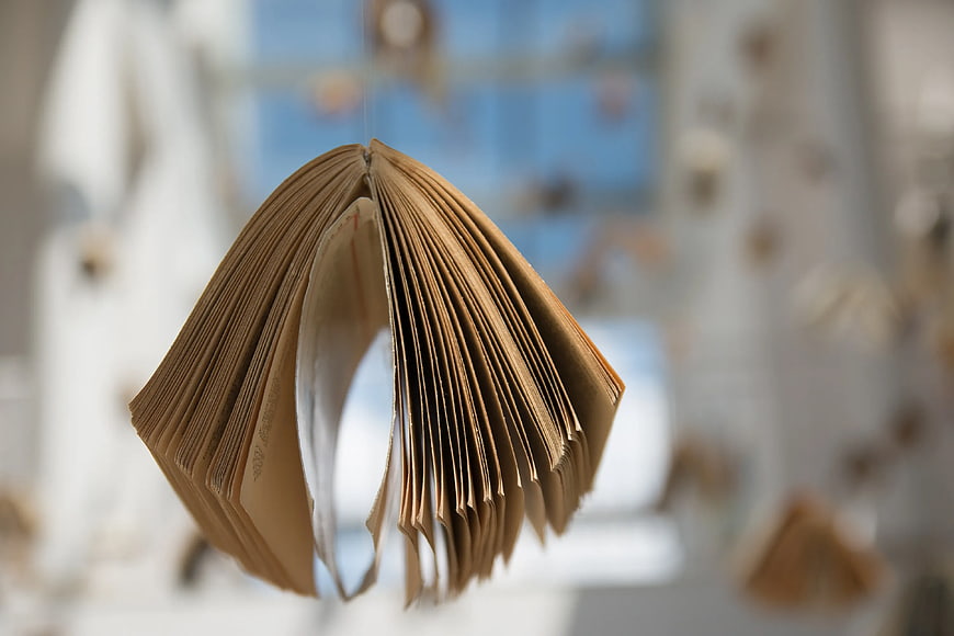 Hanging Open Book Sculpture with Blurred Background