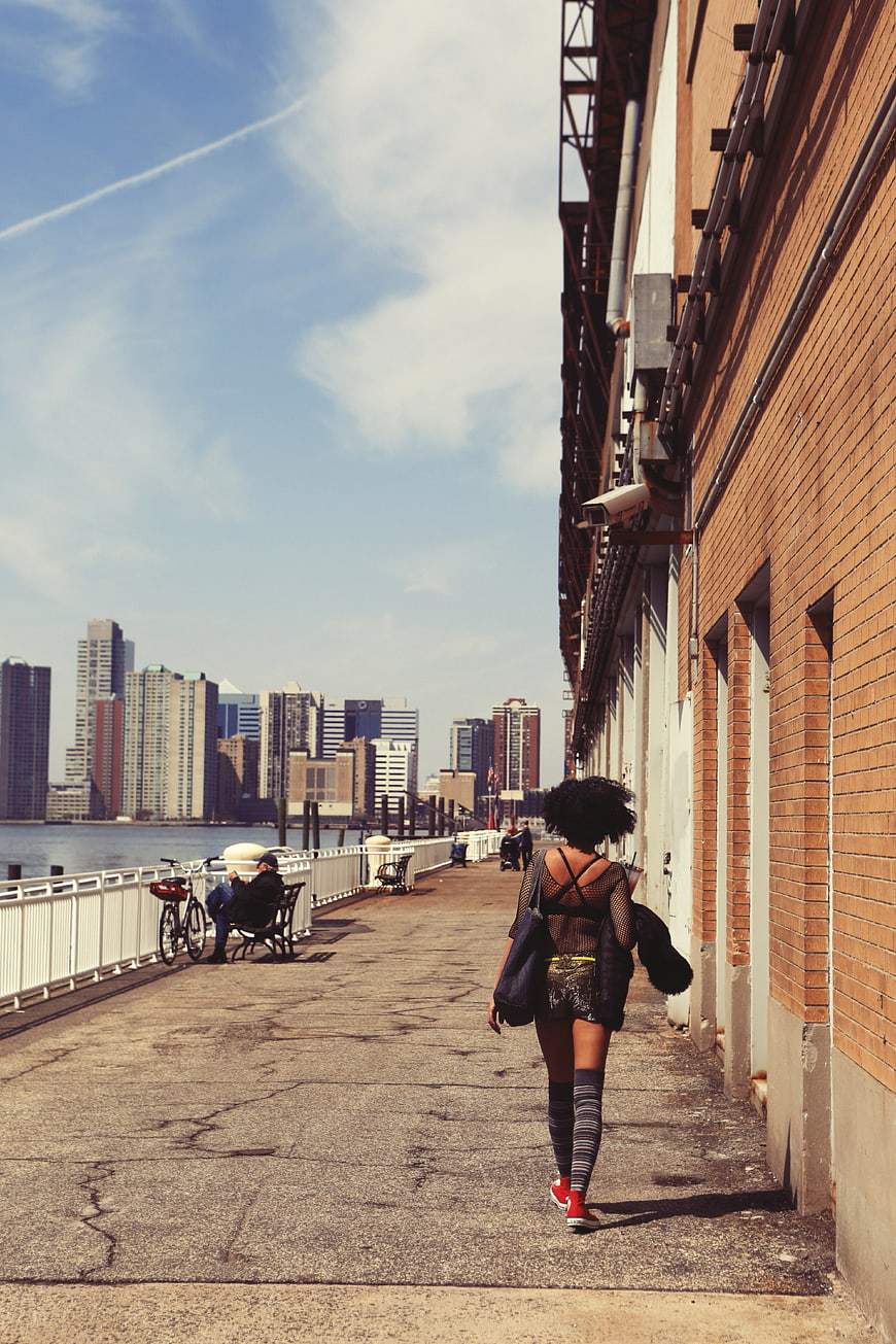 Woman Walking Along Urban Waterfront Promenade