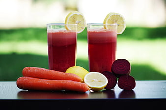Fresh Beetroot and Carrot Juice with Lemons on Table