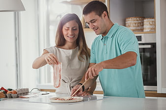 Happy couple cooking breakfast together in modern kitchen