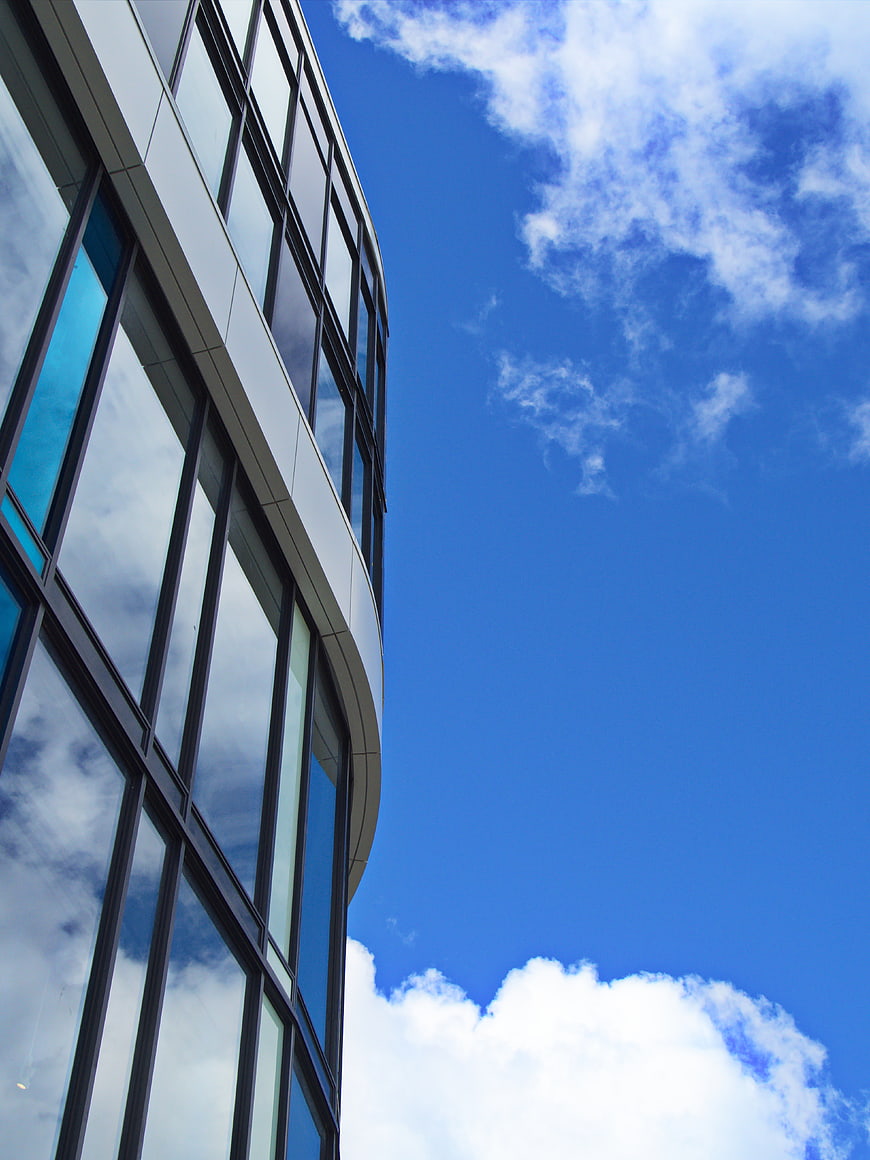 Modern Glass Office Building Facade Against Blue Sky