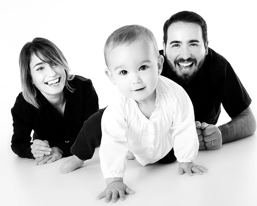 Happy family with crawling baby on white background