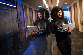 Woman with tablet in server room reflection