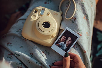 Yellow Instant Camera and Polaroid Photo on Floral Dress
