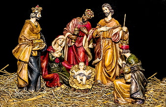 Traditional Nativity Scene Figures on Straw Background
