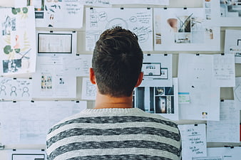 Man Analyzing Design Mood Board in Creative Workspace