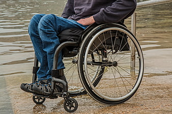 Person in wheelchair by water edge