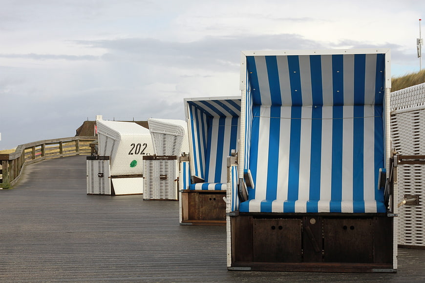 Blue and white striped beach chairs on a wooden pier