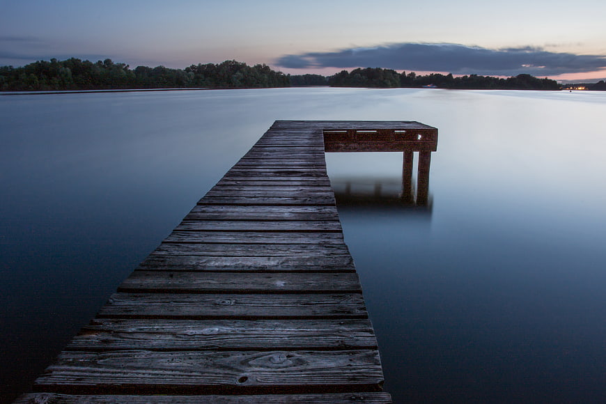 Serene Wooden Pier on Calm Lake at Dusk