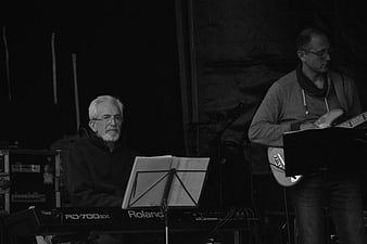 Black and white photo of musicians playing keyboard and guitar