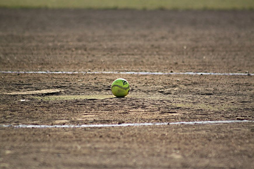 Softball on dirt field with white chalk lines