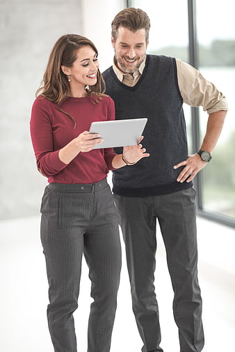 Happy business couple using tablet in modern office