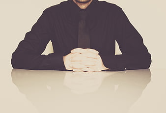 Businessman in Black Shirt and Tie Sitting at Desk