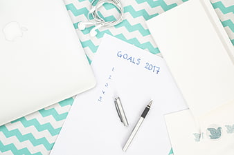 Flat lay of 2017 goals list with laptop and stationery
