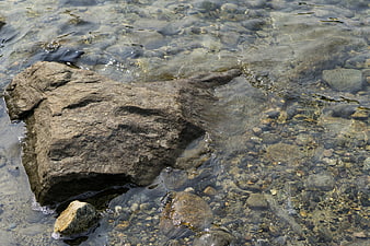 Clear Water Flowing Over Rocks and Pebbles