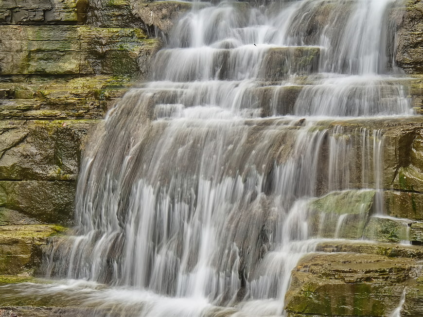 Long exposure cascading waterfall flowing over mossy rocks