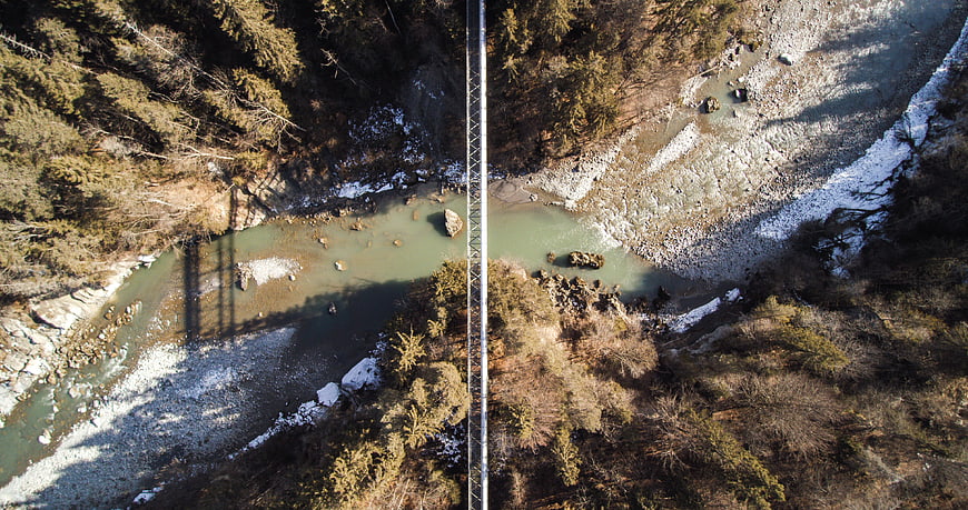 Aerial view of suspension bridge over river in forest