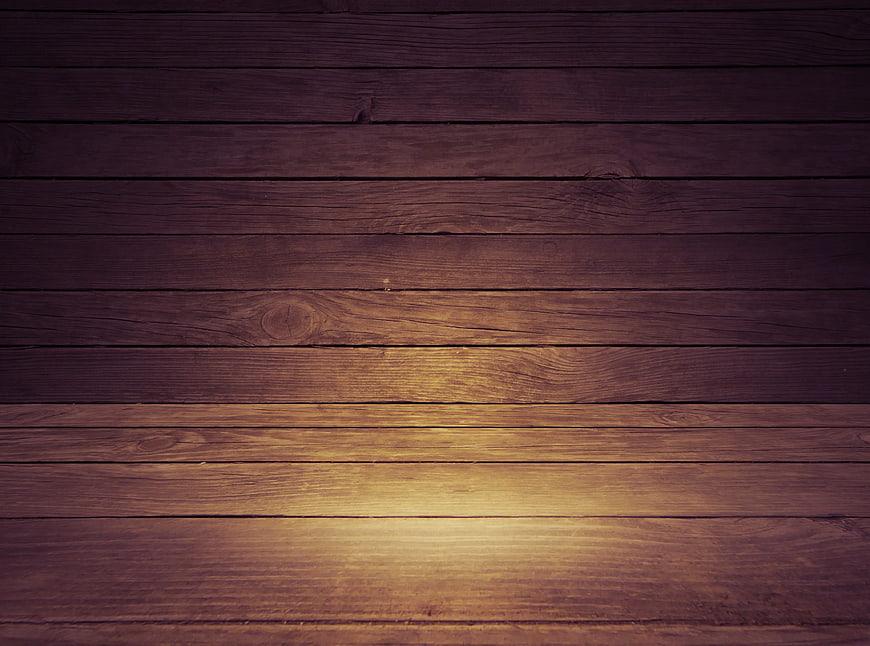 Dark rustic wooden plank background with warm spotlight glow