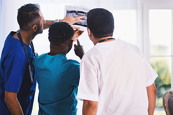 Diverse medical team analyzing x-ray film in hospital