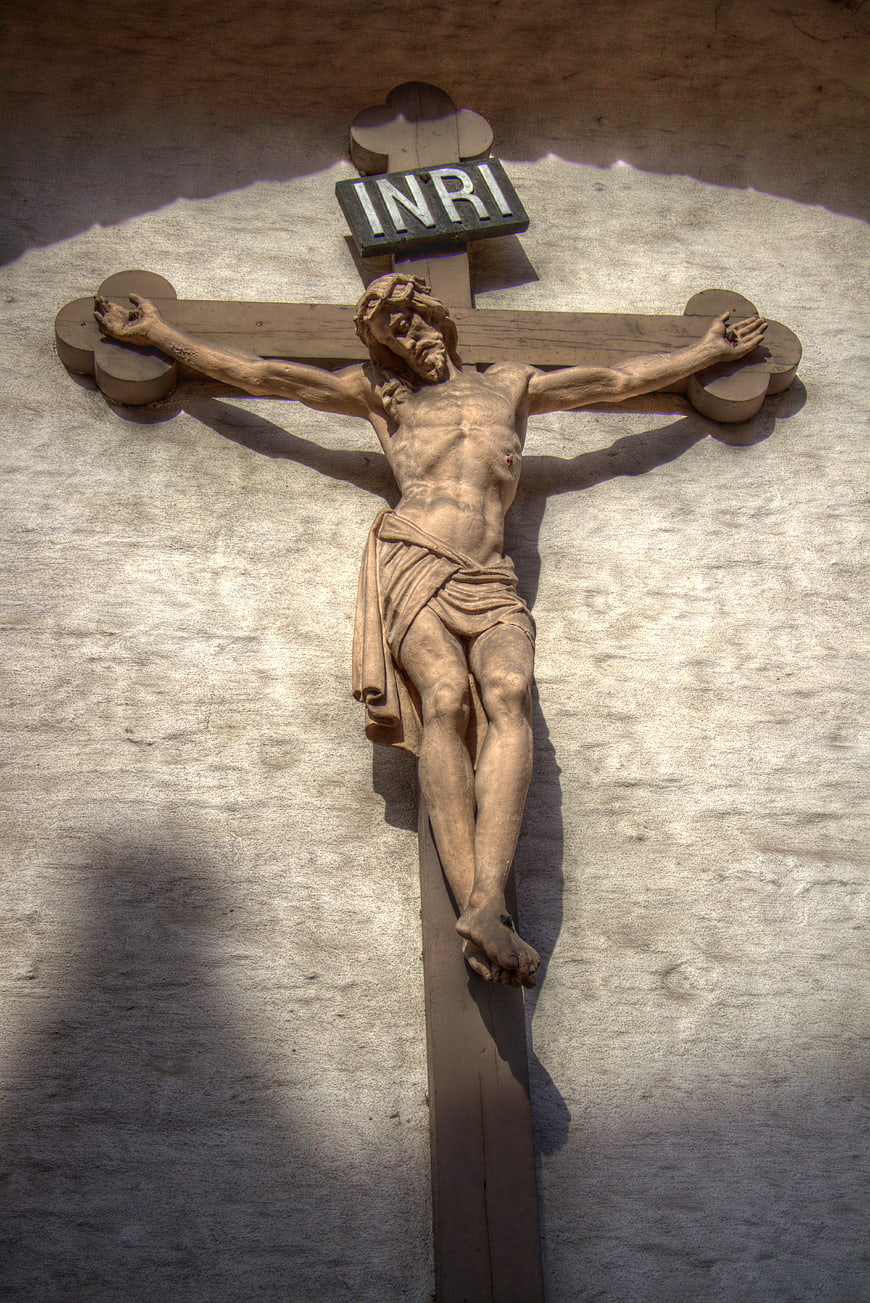 Wooden Crucifix with INRI Plaque on Textured Wall