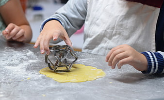 Child using cookie cutter on dough
