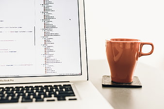 Orange Coffee Mug and Laptop on White Desk