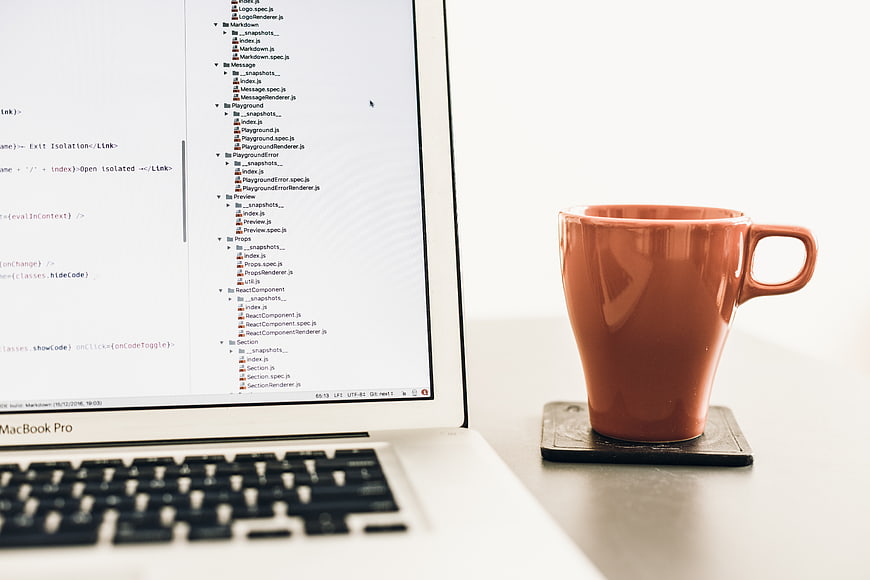 Orange Coffee Mug and Laptop on White Desk