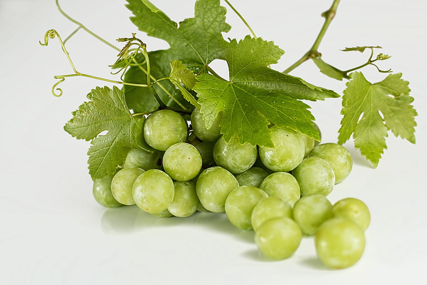 Fresh Green Grapes with Leaves on White Background