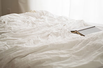 Cozy Bedroom Scene With White Linens And Book