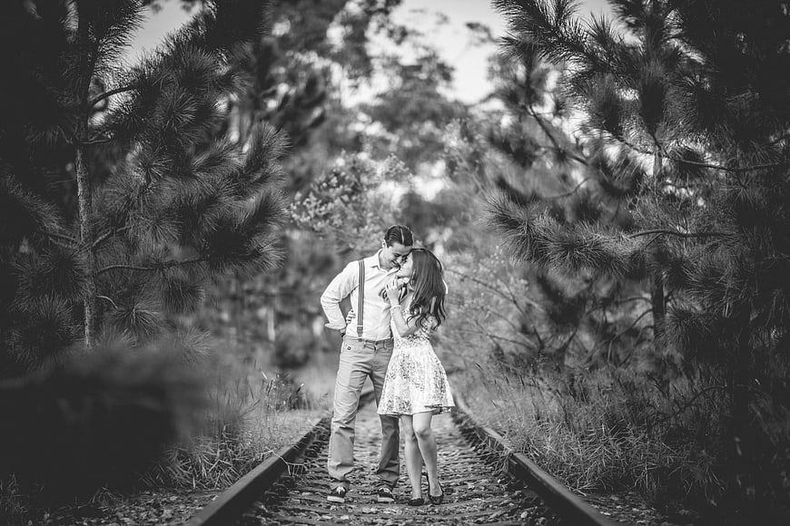 Romantic couple on railway tracks in black and white