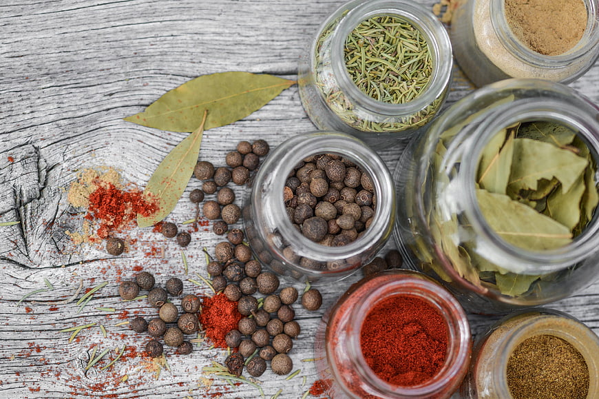 Top View of Assorted Spices in Glass Jars on Rustic Wood