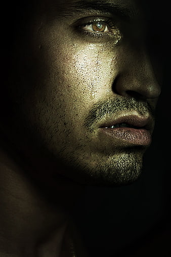 Close-up portrait of a sweating man with a tear