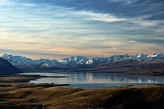 Snow-Capped Mountains Reflected in Calm Lake at Sunset