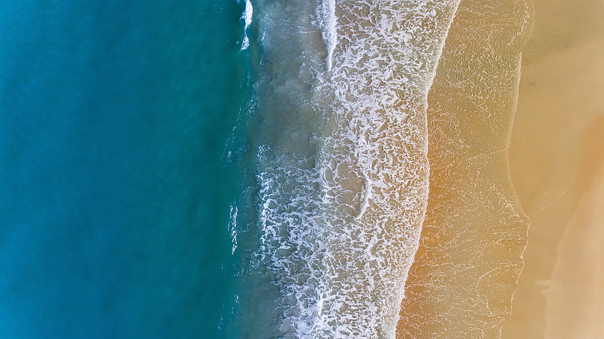 Aerial View of Turquoise Ocean Waves Crashing on Sandy Beach
