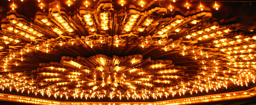 Glowing golden chandelier with radial light pattern
