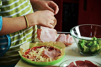 Child Preparing Homemade Pizza With Toppings In Kitchen