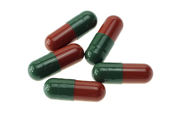 Red and Green Medicine Capsules on White Background