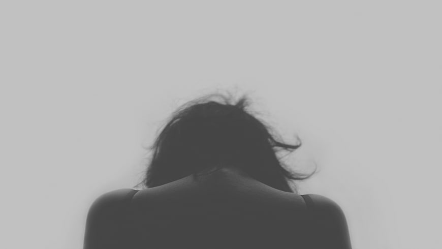Silhouette of Woman's Back and Hair Against White Background